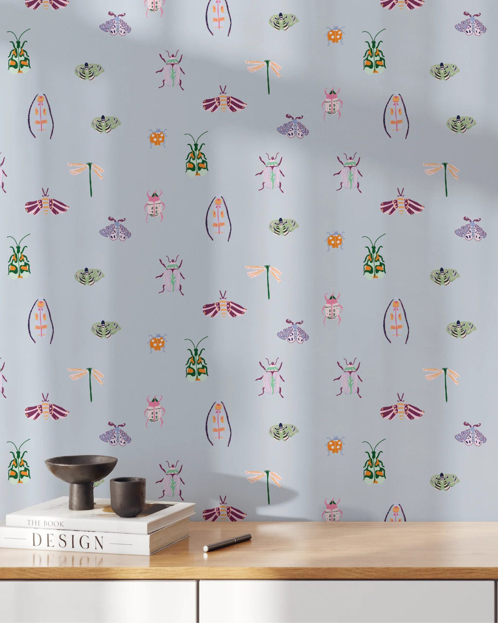 Bugs wallpaper featuring illustrated dragonflies, ladybugs and beetles on a powder blue backdrop, adding a whimsical touch to a styled room interior | Funky Paper Co