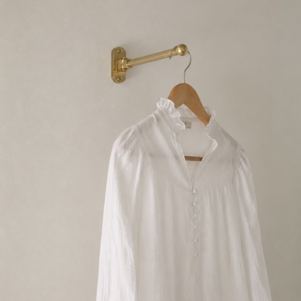 A decorative laundry room drying rack holds a white linen shirt. The rack would pair well with Funky Paper Co. wallpapers.