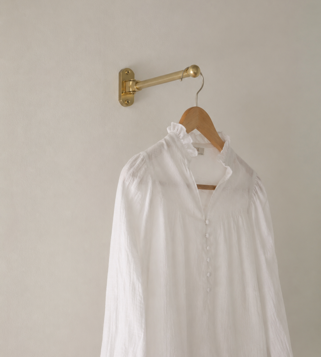 A decorative laundry room drying rack holds a white linen shirt. The rack would pair well with Funky Paper Co. wallpapers.
