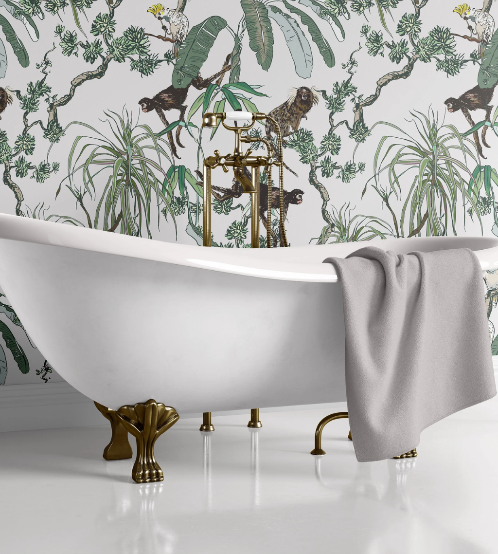 A white clawfoot tub features a Manila white wallpaper background, with monkeys and plants.