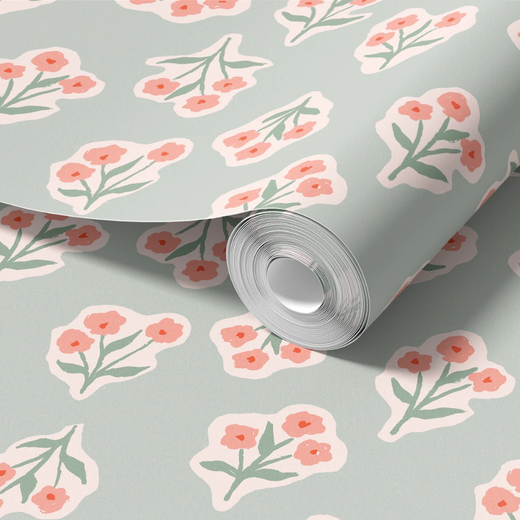 Garden flowers wallpaper with chunky pink bouquets outlined in white on a soft sage green background.