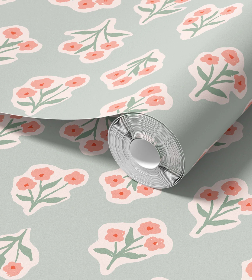 Garden flowers wallpaper with chunky pink bouquets outlined in white on a soft sage green background.