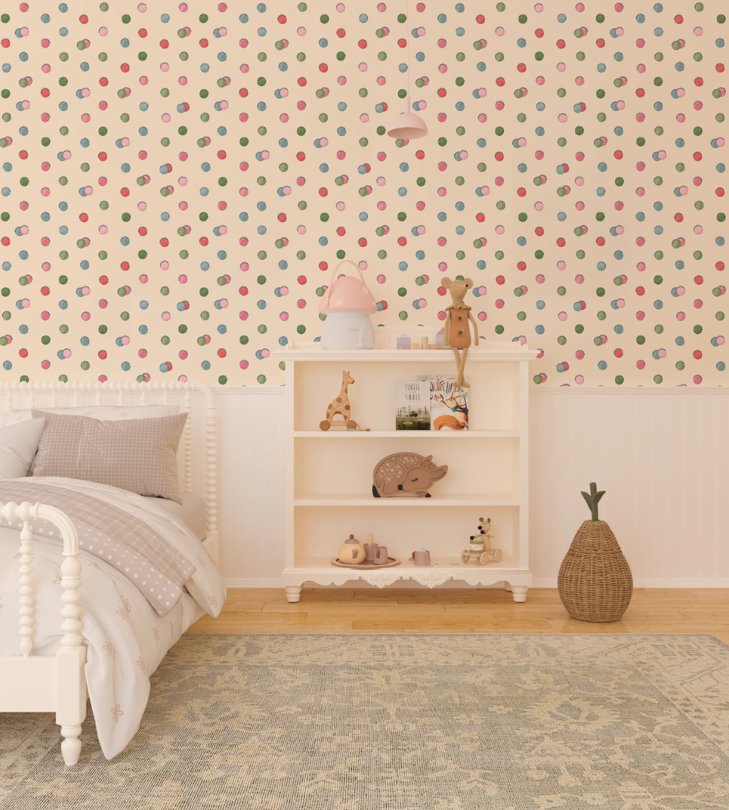 Child's bedroom with retro macaroons wallpaper with a green, blue, pink, and red polka dot pattern on a cream background.
