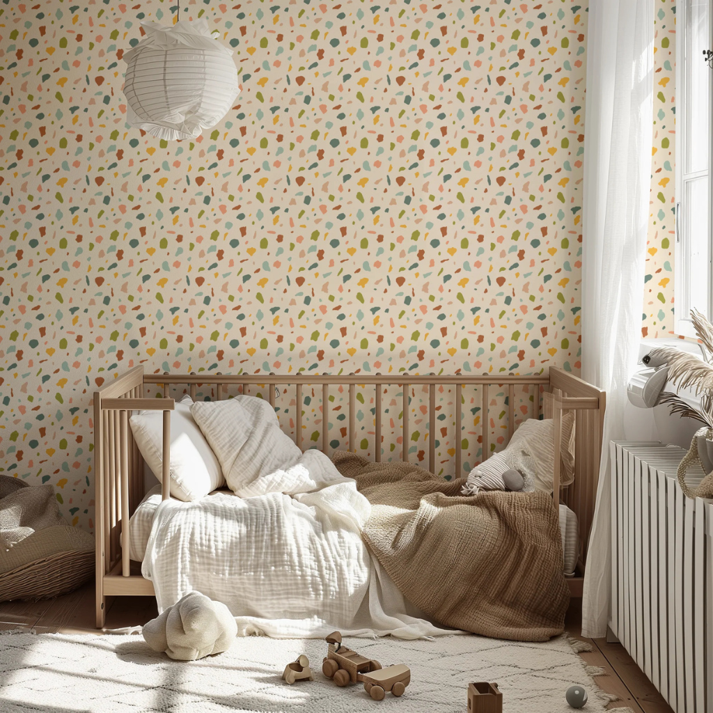Southwest boho terrazzo wallpaper with green, teal, and burnt orange speckles on a creamy yellow background in a nursery.