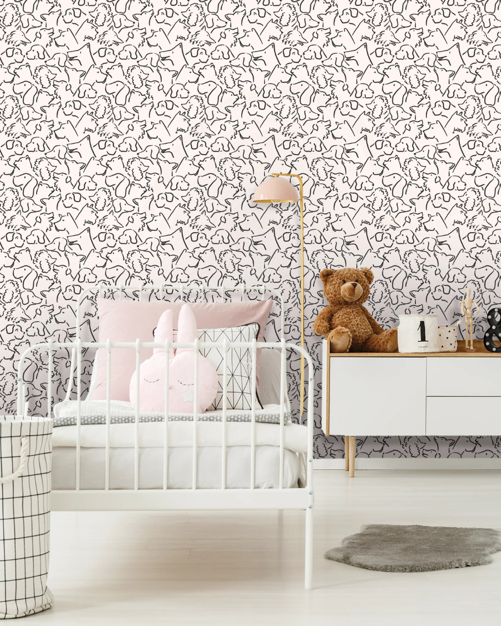 Playful Pups black and white dog wallpaper in a white and pink nursery with iron bed frame