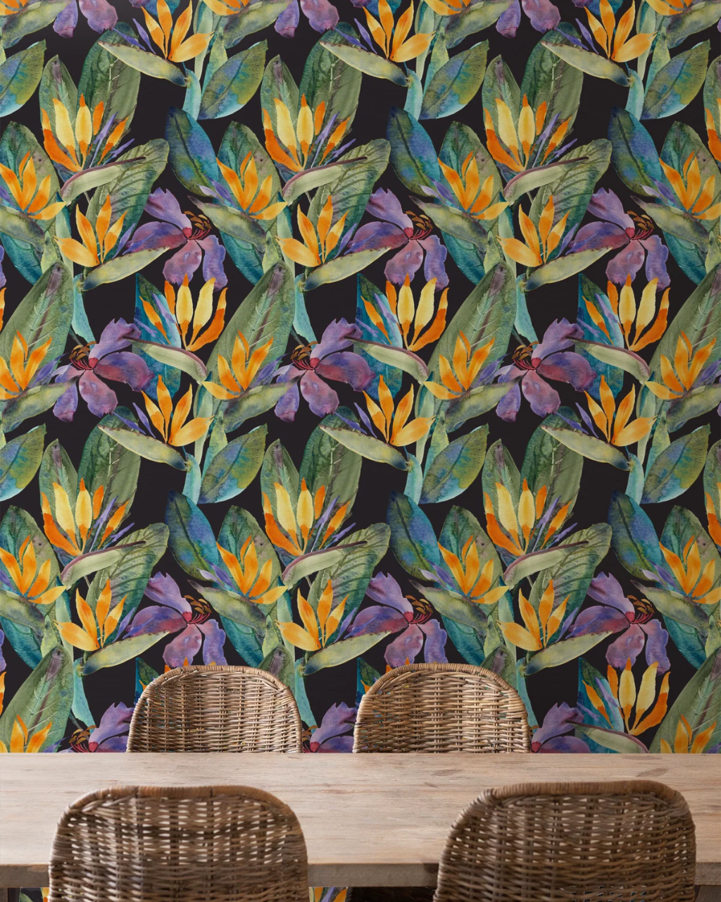 A tropical floral wallpaper pattern featuring purple irises, yellow tropical bird of paradise flowers, and green leaves on a dark background, shown behind a light wood table and three woven wicker chairs.